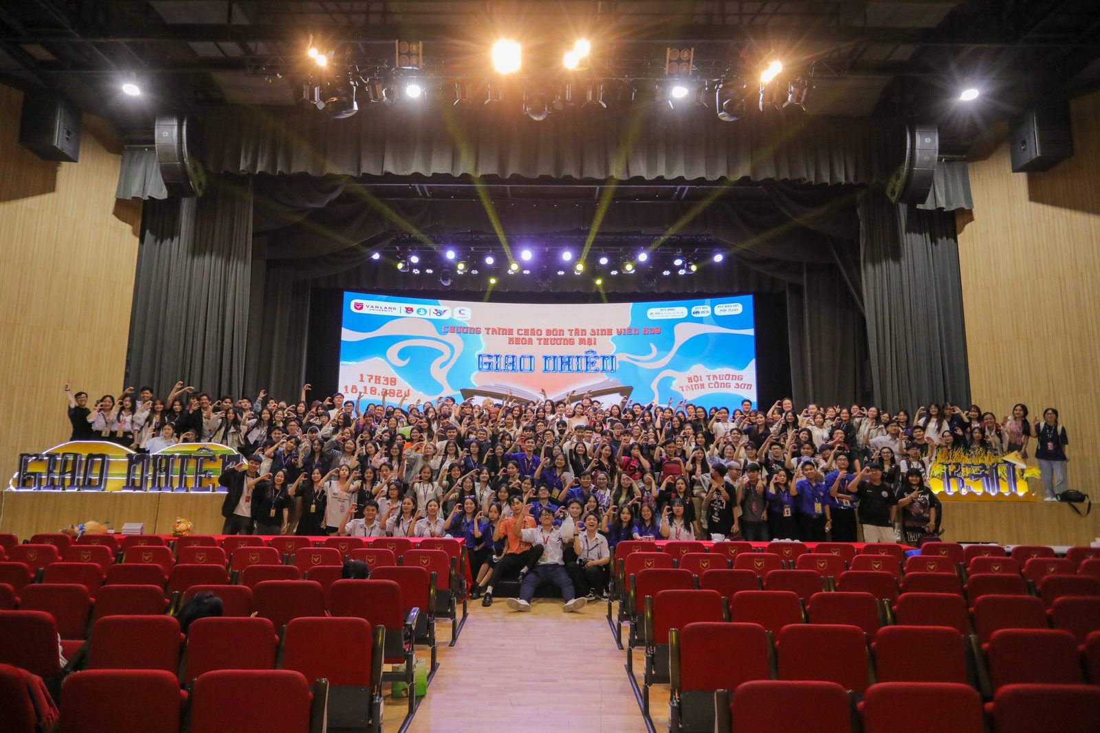Whole-hall group photo in front of the main stage